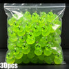 A bag filled with bright lime green glow-in-the-dark resin charms shaped like aliens and ducks.