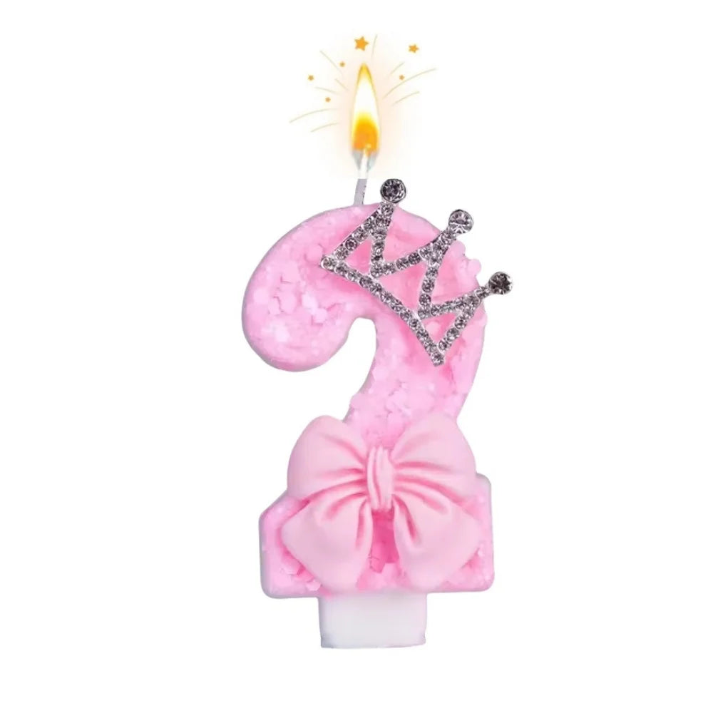 Pink bow crown number 9 birthday candle with a lit flame