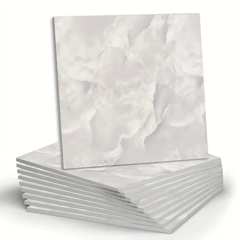 A stack of white marble peel-and-stick wall panels showing natural veining.