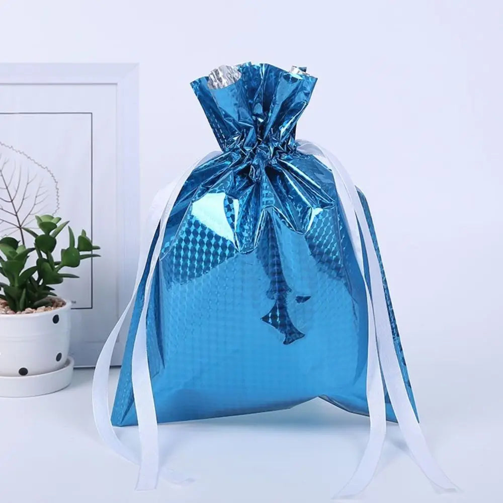 A blue festive drawstring gift bag with a silver ribbon and designs of Santa and a snowman.