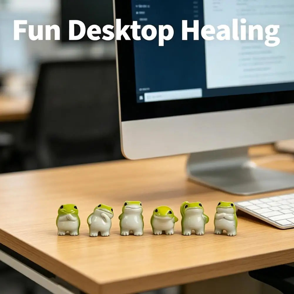 A set of six cute mini resin frog figurines in various shades of green and beige arranged on a wooden desk.