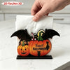 A black and orange Halloween pumpkin ghost tissue box cover with bats and cats on a wooden acrylic tabletop decor.