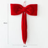 A single red velvet Christmas tree bow ornament hanging against a white background.