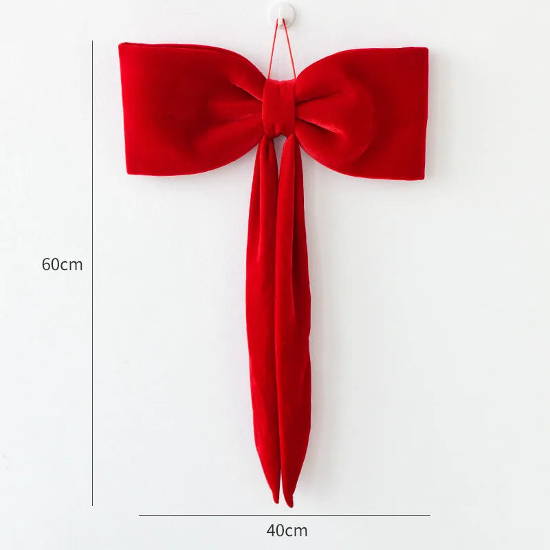 A single red velvet Christmas tree bow ornament hanging against a white background.