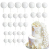 A set of white foam cake toppers on sticks, including various shapes and floral designs.