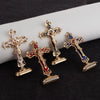 A set of three gold metal crucifix desk crosses with self-adhesive bases and blue enamel details.