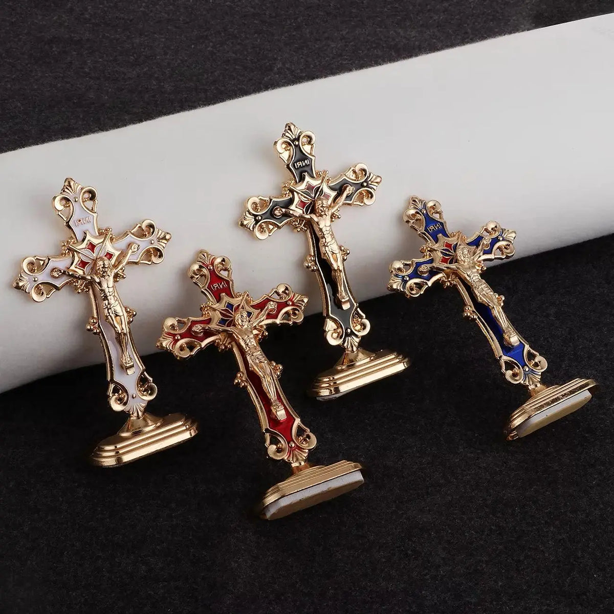 A set of three gold metal crucifix desk crosses with self-adhesive bases and blue enamel details.