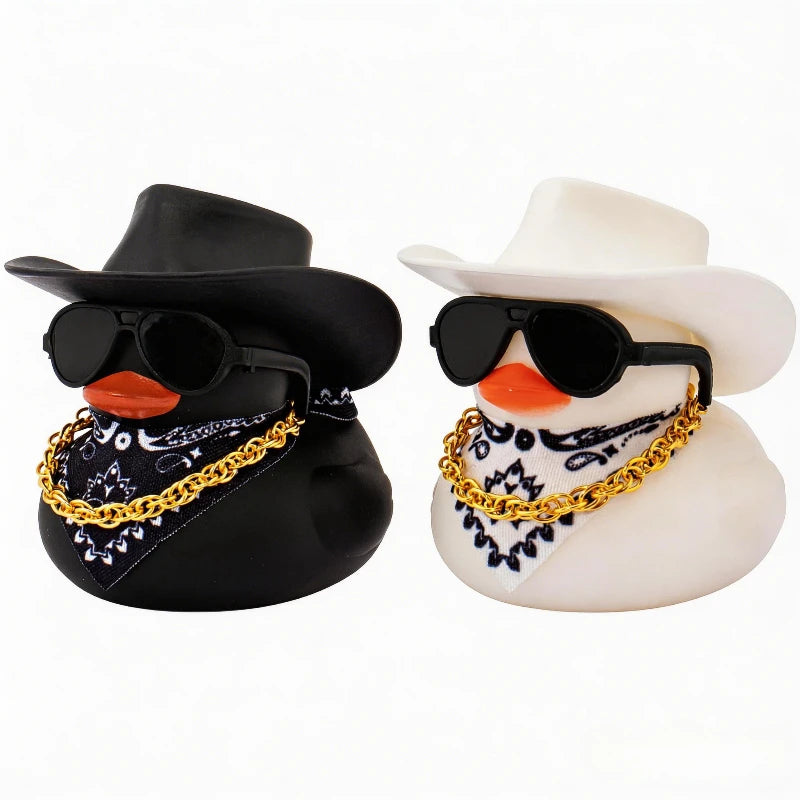 A pair of rubber duck car dashboard decorations shaped like cowboys wearing hats and sunglasses.