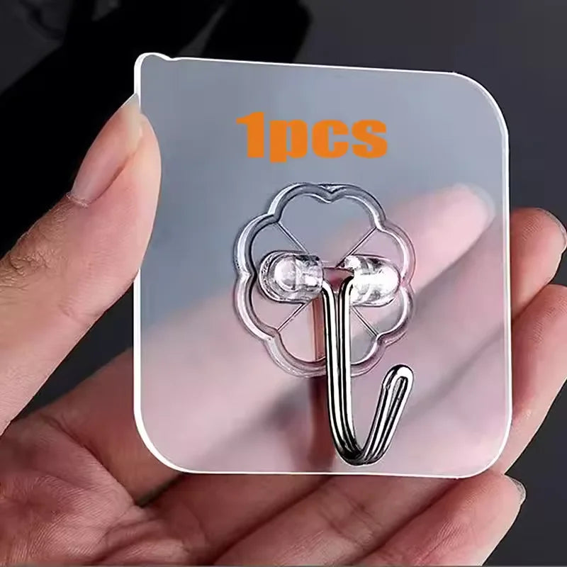 A hand holds a clear adhesive tile with one silver rotating hook attached, showing a single piece of a no-drill wall hook pro