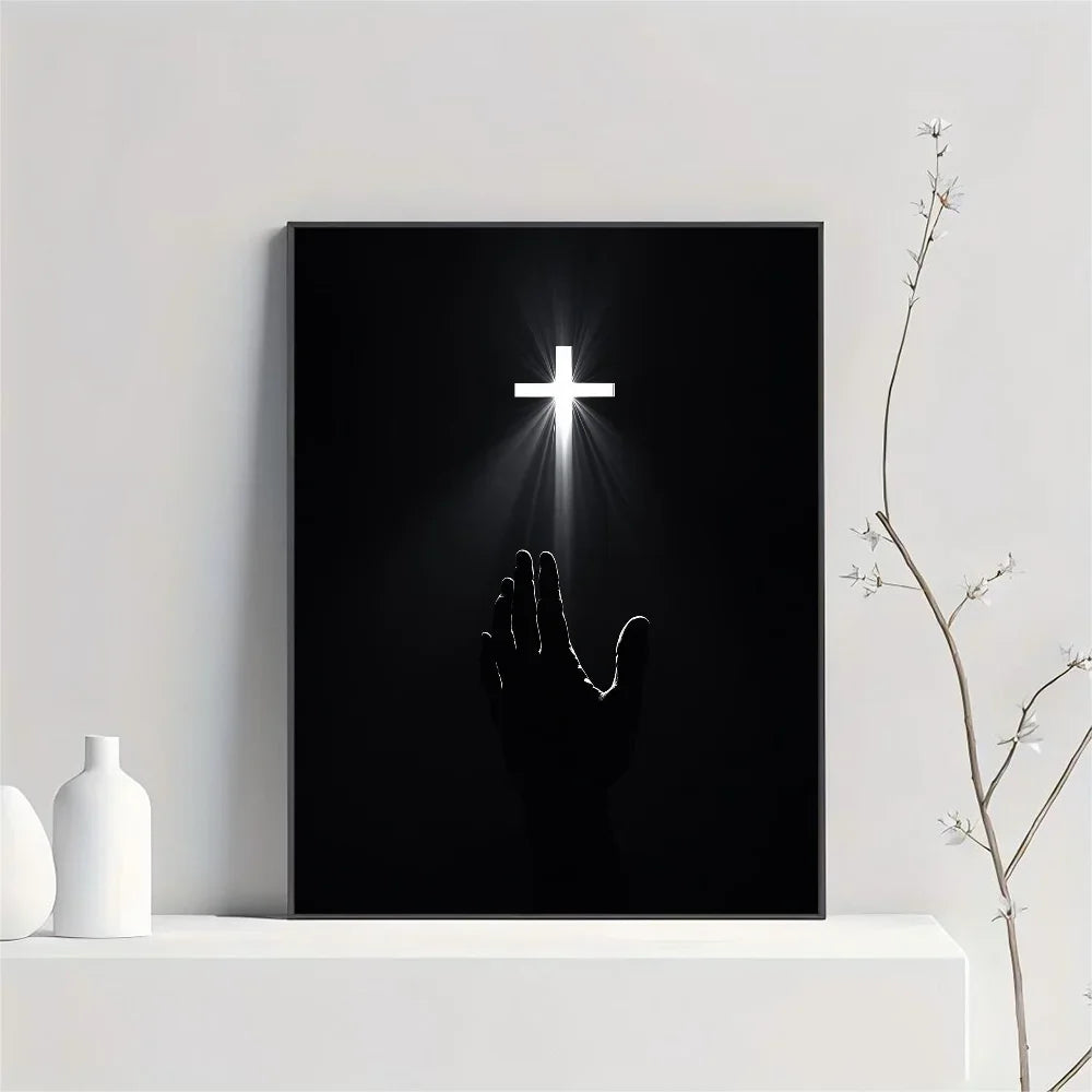 Black canvas wall art featuring a glowing cross illuminating a hand print.