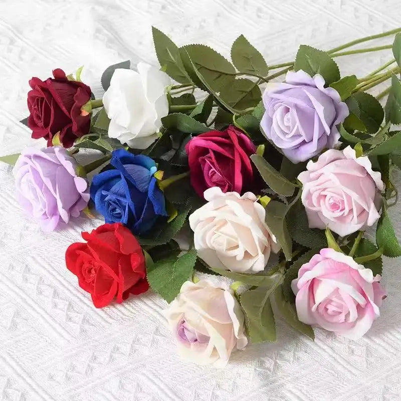 A bouquet of realistic velvet artificial roses in shades of red, pink, purple, and white.