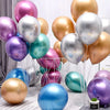 A collection of chrome metallic balloons in various shades including pink, silver, gold, and purple arranged on a white surfa