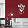 A red wall decorated with a set of silver heart-shaped acrylic mirrors.