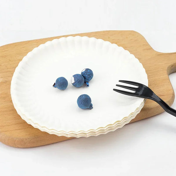 Three dark blue paper plates resting on a wooden board.