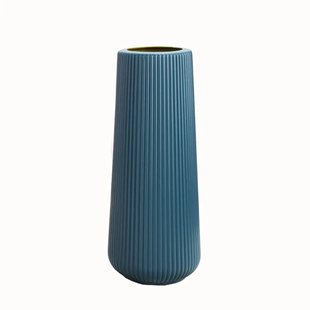 A tall, ribbed, blue plastic vase with a gold rim.