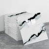 A stack of faux marble self-adhesive wall tiles featuring black veining on a gray background.