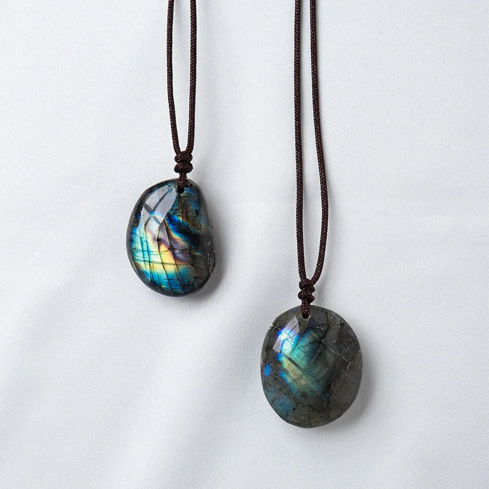 A dark blue and green labradorite gemstone pendant on a dark brown leather cord.