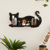 A black cat floating shelf displaying crystals, candles, and moon phase decor on a white wall.