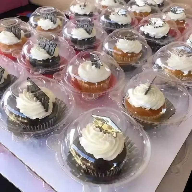A display of dark chocolate cupcakes with white frosting in clear plastic boxes.
