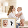 A wooden photo frame kit for baby and pet paw prints showing a baby's face and a paw print.