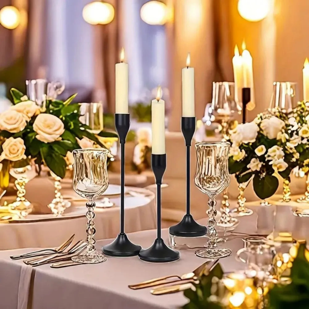 A table setting featuring minimalist Nordic round base candle holders and white roses on a linen tablecloth.