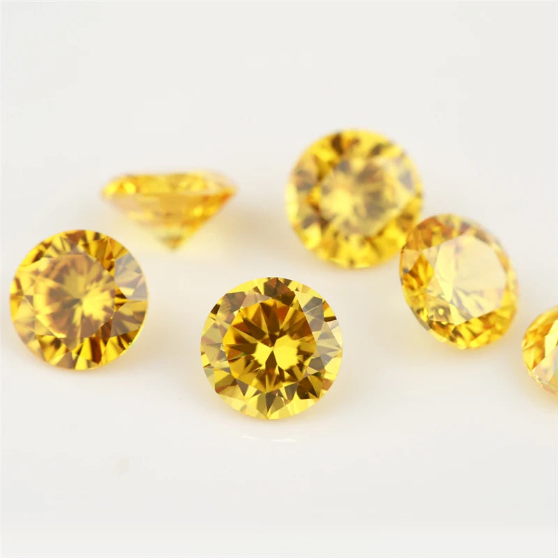 A collection of round cut yellow cubic zirconia loose stones of various sizes on a white background.
