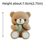 A light brown cartoon teddy bear figure with a green heart detail, shown from the side.