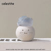 A light blue celestite crystal in a bean-shaped white stone is displayed on a surface.