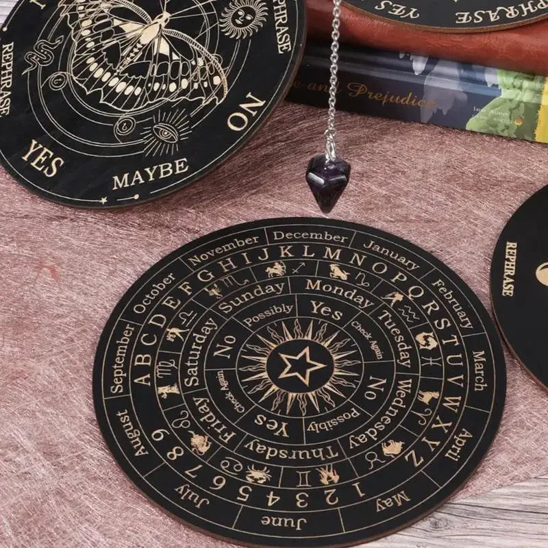 A black wooden pendulum board with zodiac signs and words like Yes No Maybe on it.