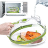 A hand holds a transparent microwave splatter guard with a steam vent and handle over a piece of salmon.