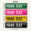 A set of five rectangular metal street signs in different colors and sizes, labeled with customizable text.