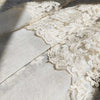Beige sheer curtain fabric featuring delicate floral embroidery and lace trim.