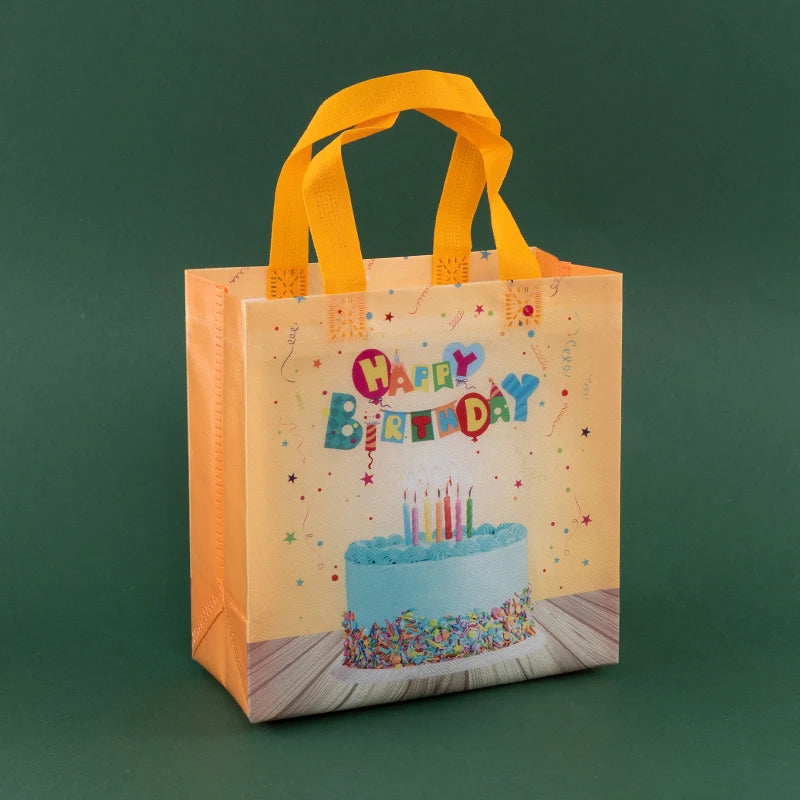A square, light orange reusable gift bag with a yellow ribbon and colorful birthday decorations.