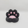 A black silicone cat paw shaped phone stand with pink stress relief pads.
