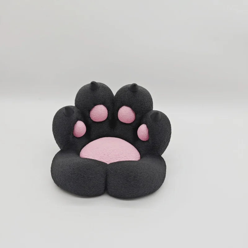 A black silicone cat paw shaped phone stand with pink stress relief pads.