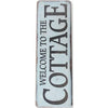 A vertical vintage metal sign with distressed white and gray paint that reads WELCOME TO THE COTTAGE