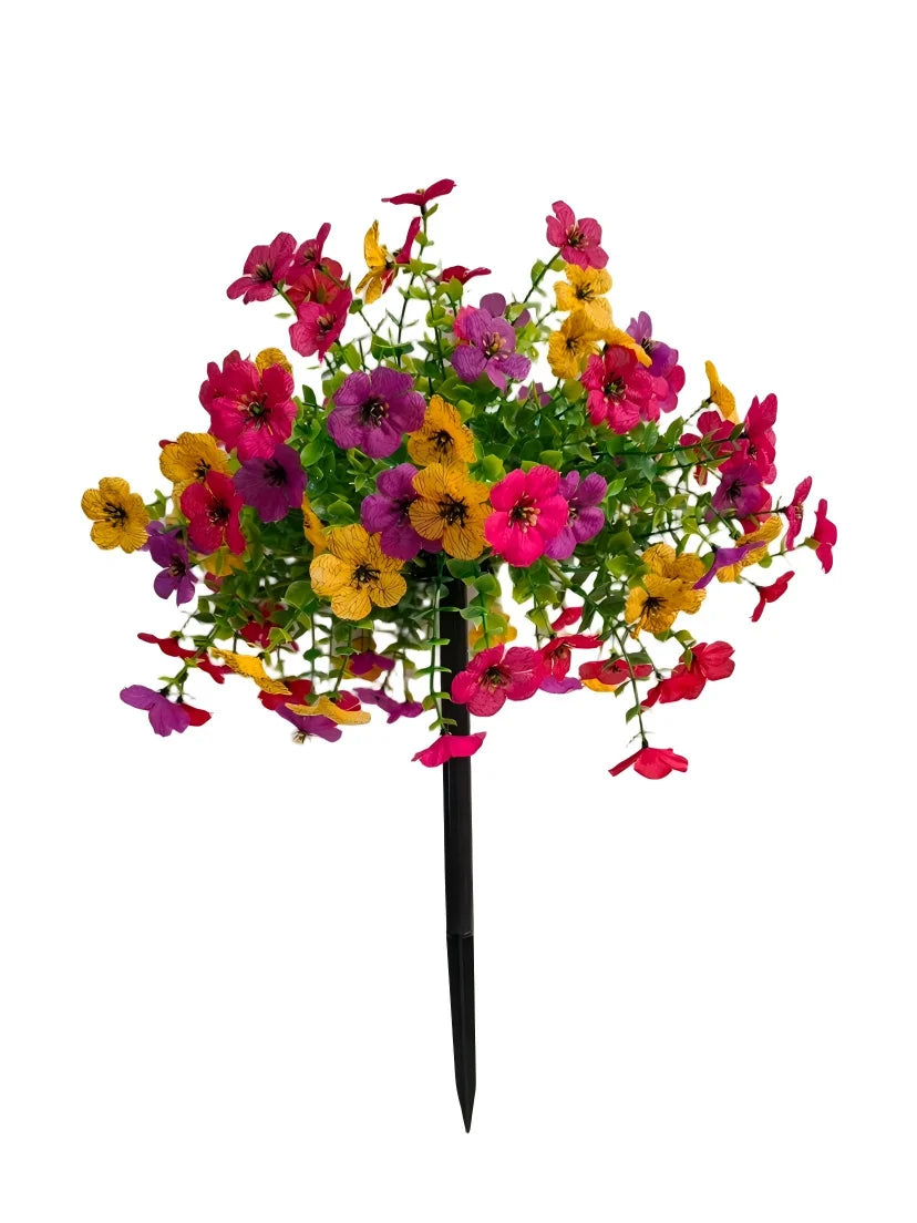 A bouquet of colorful artificial petunias in shades of pink, purple, and yellow on a black stake.