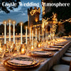 A long table set for a castle wedding atmosphere with gold and white candles and ornate tableware.