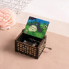 A hand-cranked wooden music box featuring a Totoro design set in a dark green box.