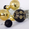 A set of black and gold glitter Christmas ball ornaments displayed on a white surface.