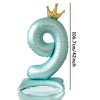 A light blue foil number balloon shaped like the number 9 with a gold crown topper.