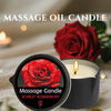A dark candle in a black tin with a red rose decoration, set on a light fabric.