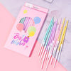 A pink card featuring colorful spiral candles and balloons, with a bundle of thin birthday candles beside it.
