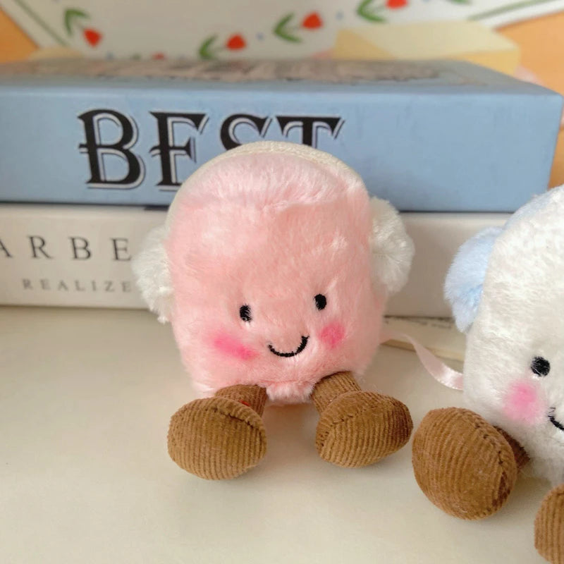 A pink marshmallow plush toy with white ears and brown feet is displayed next to a white animal plush.