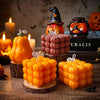 A collection of orange Halloween smiling pumpkin silicone molds, candles, and resin crafts displayed on a wooden surface.