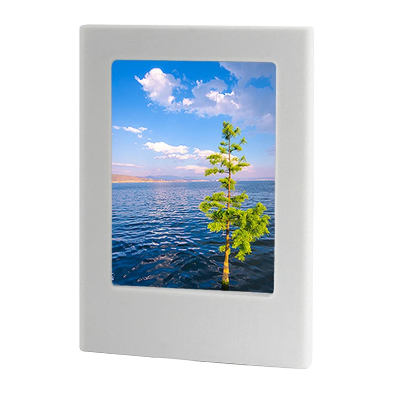 A white magnetic double-sided frame displaying a scenic view of water, sky, and a green tree.