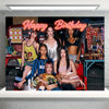 A group of five women posing in front of a festive birthday backdrop with neon text and colorful decorations.