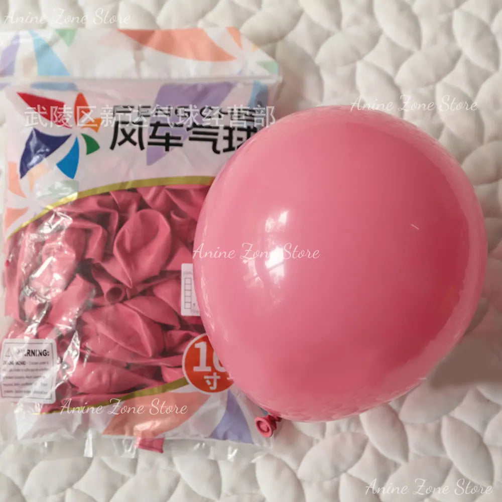 A single, large, glossy pink latex balloon is shown on a white surface next to packaging.