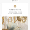 A close-up of a textured, metallic blue and gold ginkgo leaf decorative piece used as an artistic element.