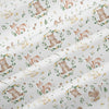 Light gray fabric with an all-over floral print featuring cute woodland animals like bears and rabbits.